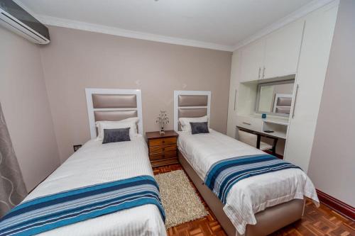 彼得马里茨堡The Musafer Travel Lodge的一间卧室配有两张床和水槽