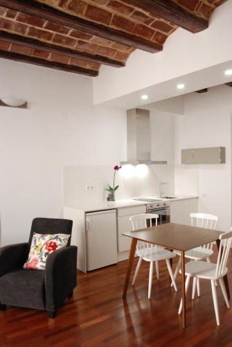 瓦伦西亚Lonja Valencia Flats的厨房以及带桌椅的起居室。