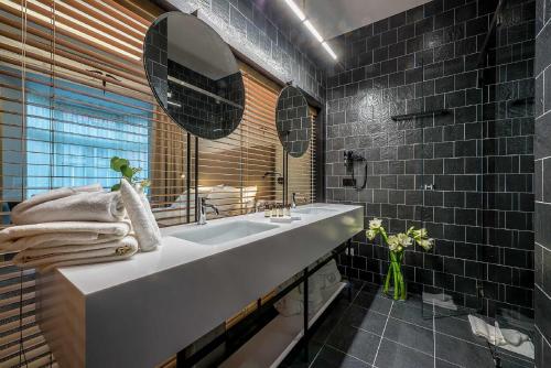 维尔纽斯阿塔格尼斯特艺术酒店的浴室设有白色水槽和黑色瓷砖
