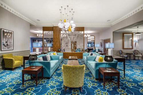 戴斯Leonardo Hotel and Conference Venue Aberdeen Airport的客厅配有蓝色的沙发和椅子