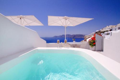 伊亚Onar Villas - Onar Hotels Collection的一座带遮阳伞的别墅边的游泳池