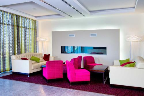 卡卢加卡卢加安布萨达酒店的客厅配有粉色和白色家具