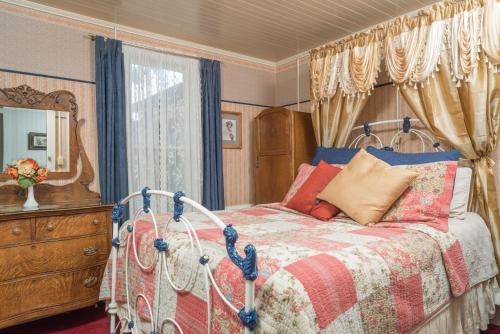朱利安Julian Gold Rush Hotel的一间卧室配有一张床、梳妆台和镜子