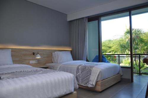 乌鲁瓦图巴东巴东酒店的酒店客房设有两张床和一个阳台。
