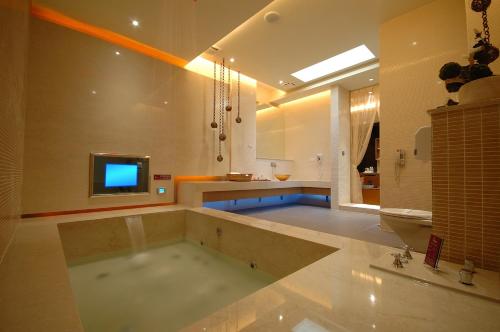 新店挪威森林精品SPA汽车旅馆的一间带浴缸的大浴室,内配电视