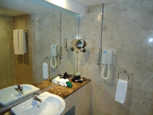 阿布扎比阿詹辛拉俱乐部酒店的一间带两个盥洗盆和淋浴的浴室