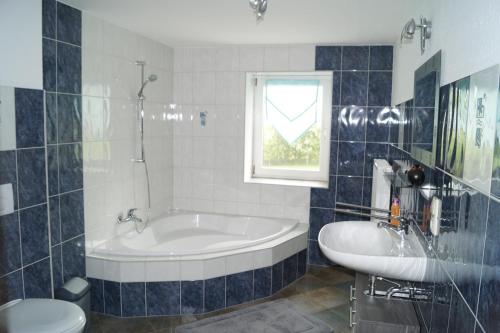 齐陶Landsauna - Pension的带浴缸、卫生间和盥洗盆的浴室