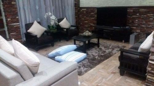 碧瑶Affordable Baguio APT的客厅配有白色沙发和钢琴