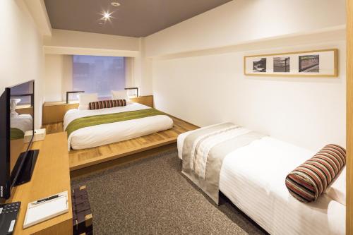 东京MYSTAYS 大森精品酒店的酒店客房配有两张床和一张书桌