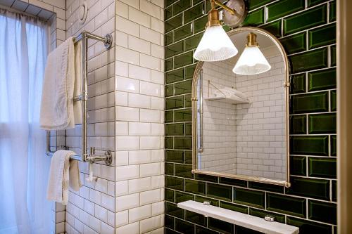 斯蒂夫尼奇Hotel Cromwell Stevenage的绿色瓷砖浴室设有镜子和水槽