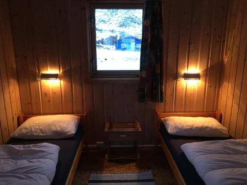 霍宁斯沃格北角露营酒店的带窗户的客房内设有两张单人床。