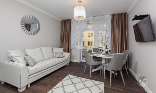 比亚韦斯托克Apartamenty City.的客厅配有白色的沙发和桌子
