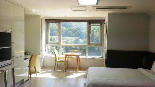 大田高恩酒店的客房设有床、桌子和窗户。