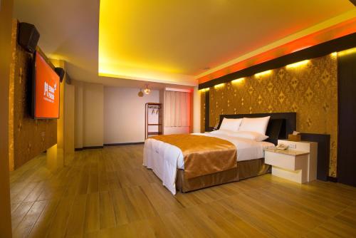 台南M宿花园汽车旅馆的酒店客房设有一张大床和一台电视。