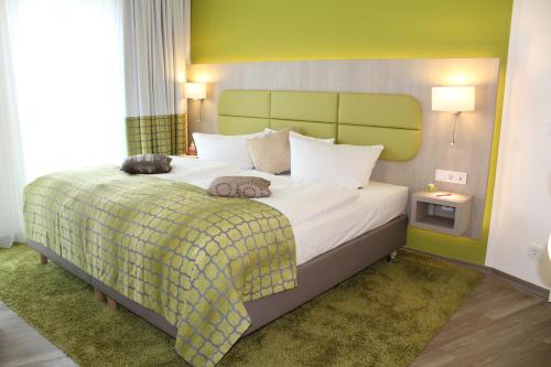爱尔福特皇帝大厅酒店的一间卧室配有一张大床和绿色床头板