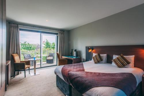 圣奥斯特尔康沃尔Spa和小屋酒店的酒店客房设有一张床和一个大窗户