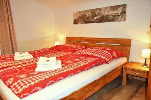 涅德劳特拉登公寓的一间卧室配有一张带红色和白色床单的大床
