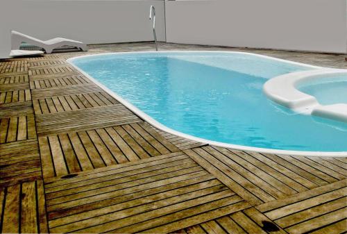 维列纳Hotel Comodoro的木制甲板上的游泳池,配有浴缸