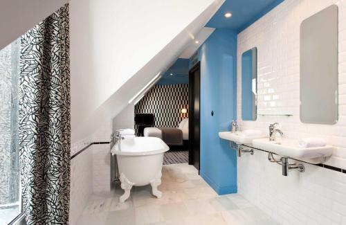 巴黎Hôtel Emile Le Marais的一间带卫生间和两个盥洗盆的浴室以及一间卧室