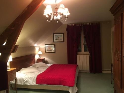 Baugéle petit clos的一间卧室配有一张带红色毯子的大床