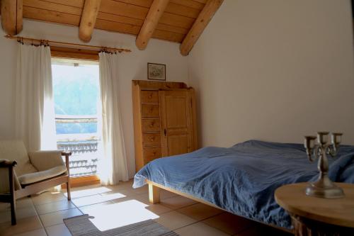 Verdabbio卡萨都斯卡住宿加早餐旅馆的卧室配有床、椅子和窗户。