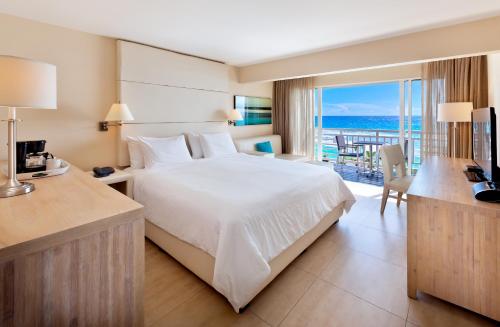 布里奇敦The Soco Hotel All-Inclusive的一间卧室配有一张床,享有海景