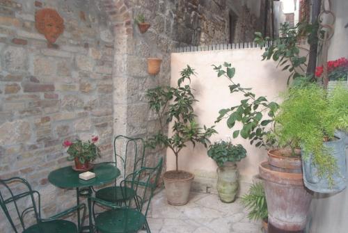 阿斯科利皮切诺Piccola corte的天井配有桌椅和盆栽植物