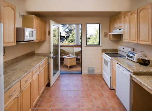 圣何塞一室公寓酒店的厨房配有木制橱柜和白色家电