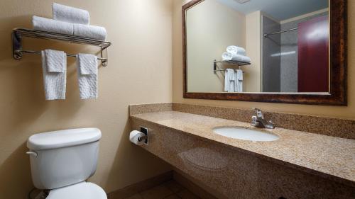 凯蒂贝斯特韦斯特百老汇套房酒店 的浴室设有卫生间和带镜子的盥洗盆