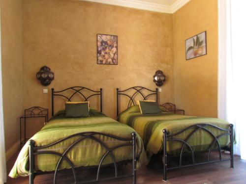 塔鲁丹特贾丹埃皮斯花园酒店的两张睡床彼此相邻,位于一个房间里