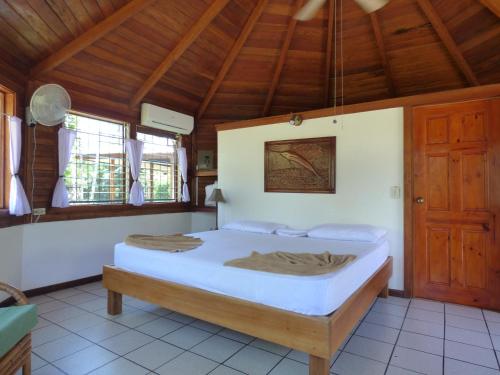 希门尼斯港Corcovado Beach Lodge的一间带一张床的卧室,位于带木制天花板的房间内