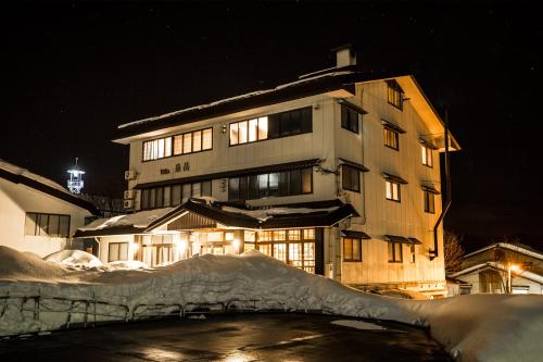 野沢野泽高山别墅酒店的一座在晚上有雪的建筑