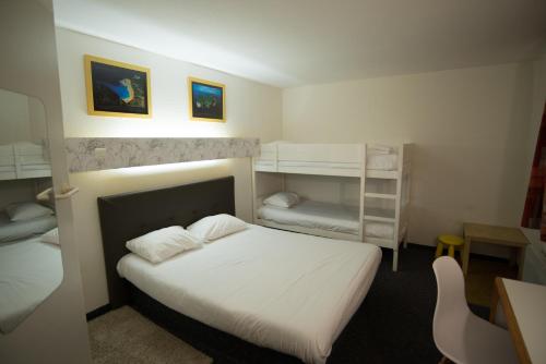 图尔hôtel QUICK Palace Tours Nord的一间卧室配有一张床和两张双层床。