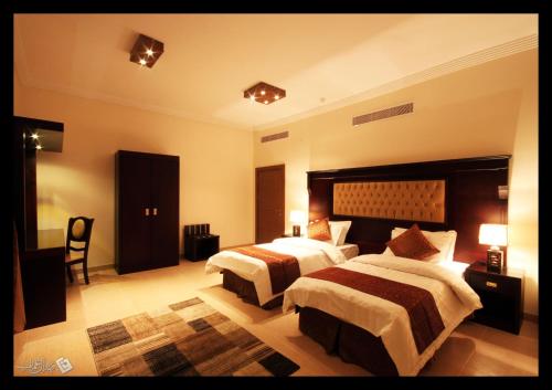 延布Taraf Yanbu的一间大型酒店客房,房间内设有两张床