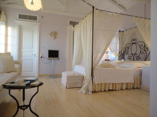 伊兹拉House Aquata的一间卧室配有一张天蓬床和一张桌子