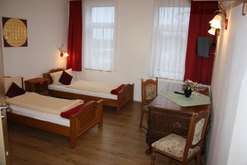 爱尔福特Fürstenhof Landgasthaus & Hotel的一间设有两张床和一张桌子及椅子的房间