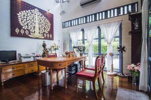 曼谷诺帕湾之家酒店的一个带桌子和红椅子的家庭办公室
