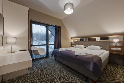 乔尔什滕戈尔斯基伊甸园公寓的一间卧室设有一张大床和一个大窗户