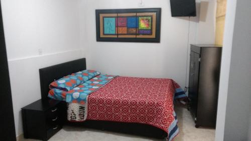 马尼萨莱斯Apartaestudios El Cable的卧室配有一张床,墙上挂着一幅画