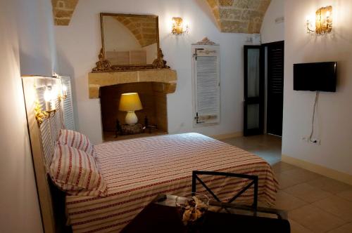 马蒂诺Dimore Ducali的一间卧室配有一张带壁炉和镜子的床