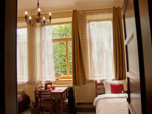 考纳斯勒克司旅馆的一间卧室配有一张床、一张桌子和一个窗户。