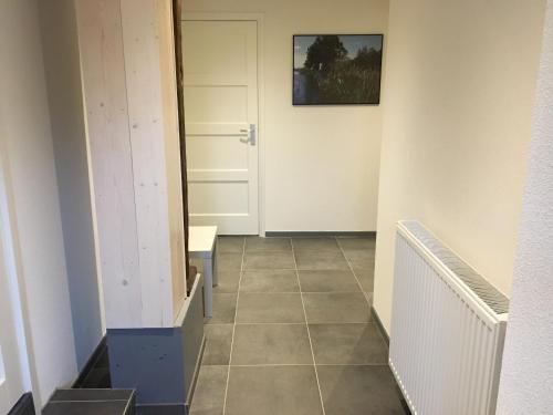 羊角村Bed & Bike De Hofstee的走廊上设有门,铺有瓷砖地板