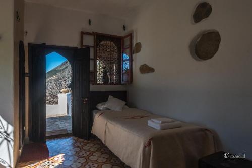舍夫沙万达尔瓦达酒店的一间卧室配有一张床,一扇门设有窗户