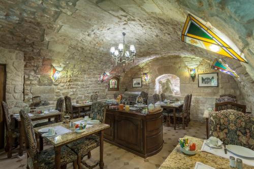 巴黎鲁尼沃圣日耳曼大酒店的石头建筑中带桌椅的用餐室