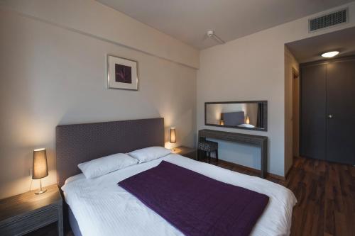 布加勒斯特海明威公寓酒店的一间带大床和电视的卧室