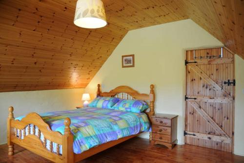 丁格尔Griffins Holiday Cottage的一间卧室设有一张床和木制天花板