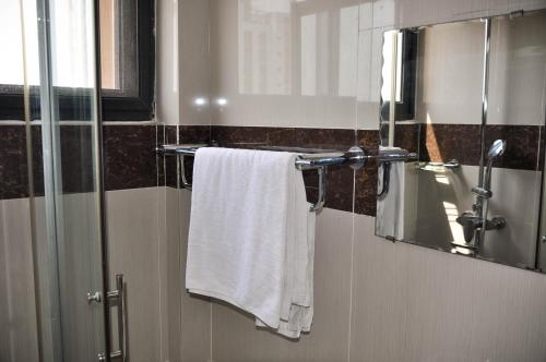 洛美Guest House Lumen的浴室提供白色毛巾和镜子