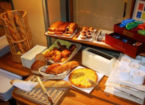贝莱甜蜜的家酒店的一张桌子,上面摆放着各种面包和糕点