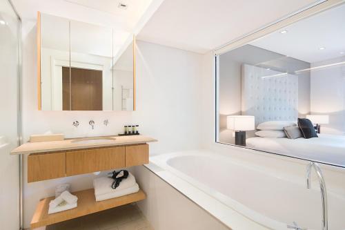 波高尔宾美爵经典酒店的带浴缸、水槽和床的浴室