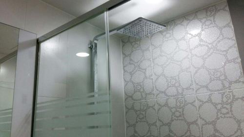 大田高恩酒店的浴室里设有玻璃门淋浴